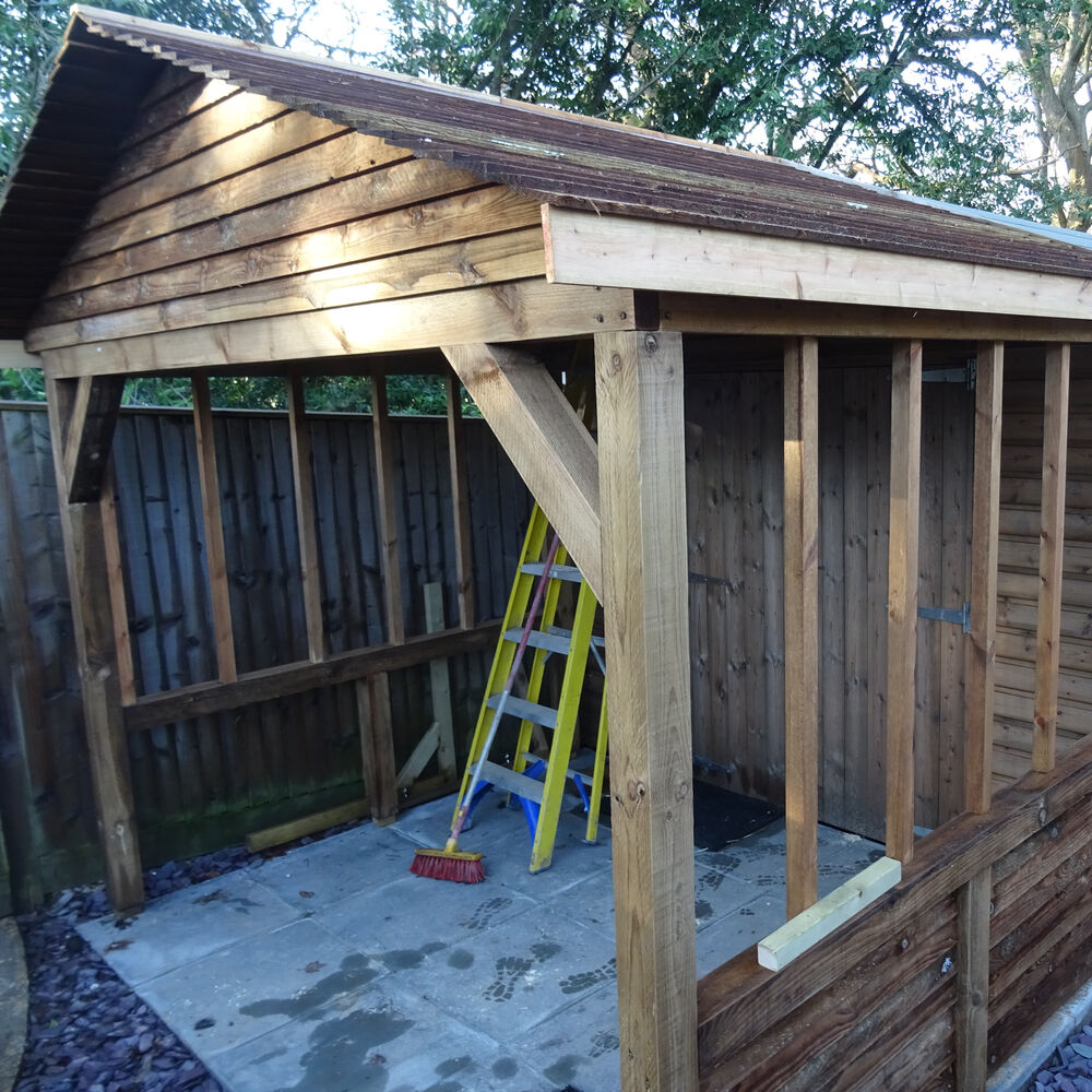 Timber lean-to and log store built by Cordreys